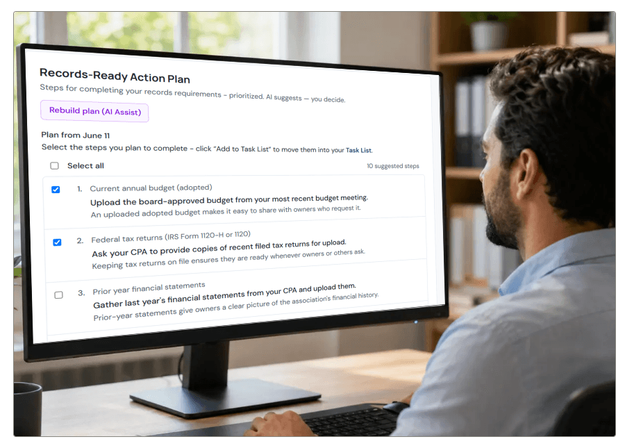 A records manager at a desk viewing the Records-Ready Action Plan on a monitor: prioritized suggested steps for an example condo association — upload the adopted budget, request tax returns and financial statements — each with a checkbox.